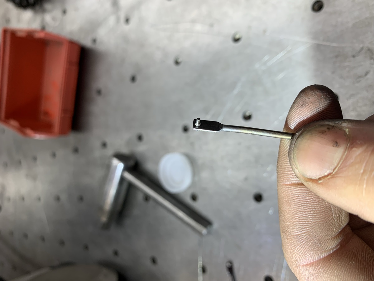 Tiny steel dowel micro laser welded to a linkage part, held between fingertips