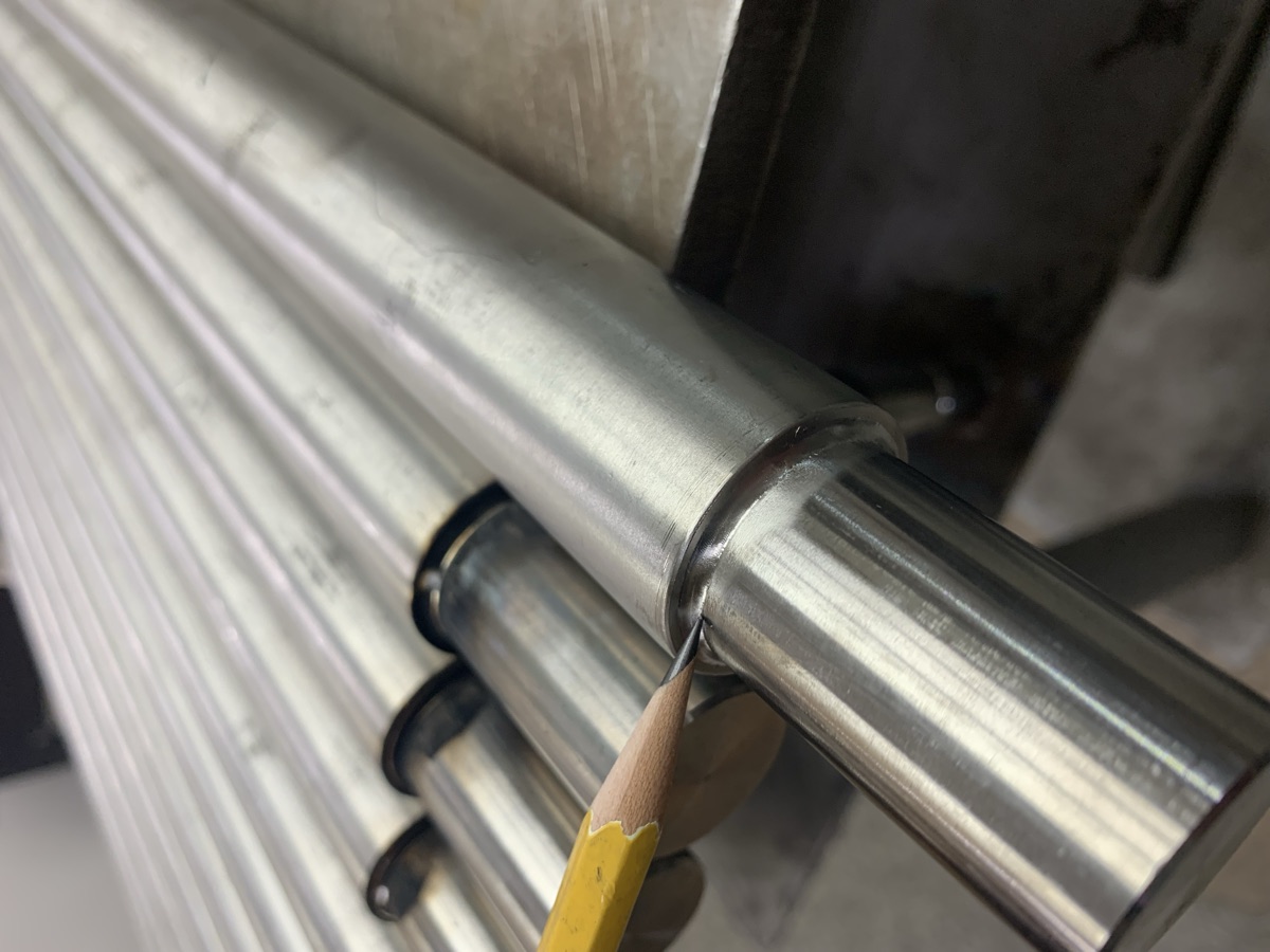 Micro laser weld joining stainless pipe to a machined part, pencil for scale