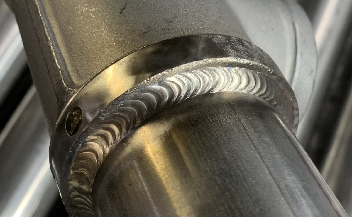 Ring of TIG weld joining a T fitting to stainless pipe