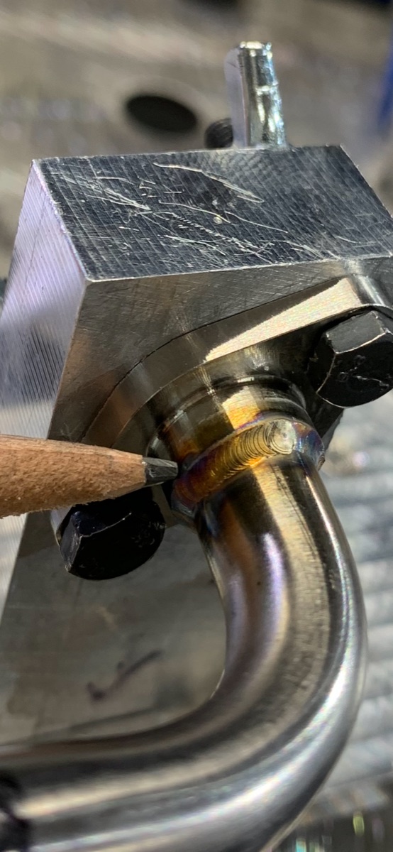 Thin-wall stainless tube TIG welded to a machined flange, pencil tip for scale